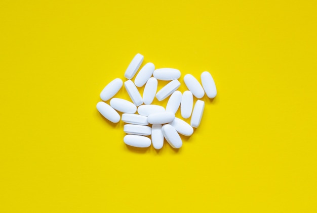 A lot of pills on a yellow background, concept of health