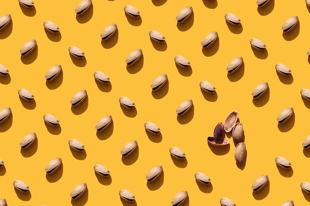 Photo a lot of pistachios on an orange background nuts pattern