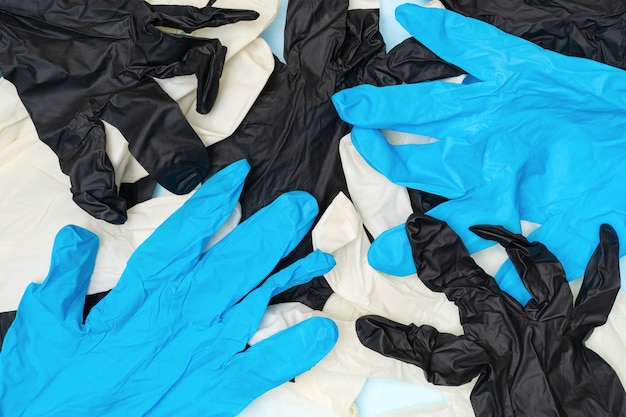 Lot of protection elastic surgical gloves white, black and blue colors. Flat lay close-up view of hygiene and protective gloves of hospital medical staff during pandemic outbreak, quarantine.