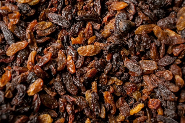 Photo a lot of raisins raisins texture as background closeup grape raisin on a tray lots of dried grape