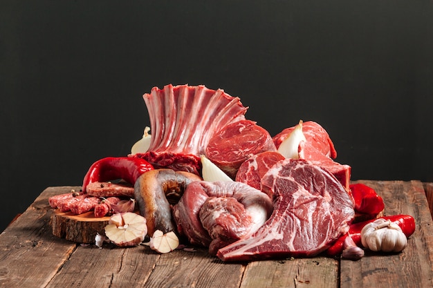 Molta carne fermentata succosa fresca cruda. bistecche di manzo crude su un tavolo di legno.