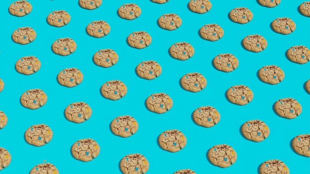 자연적인 단단한 그림자가 있는 파란색 배경 패턴에 장식된 많은 둥근 달콤한 쿠키
