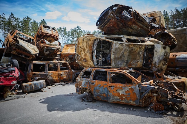 Photo a lot of rusty burnt cars in irpen after being shot by the russian military russia's war against ukraine cemetery of destroyed cars of civilians who tried to evacuate from the war zone