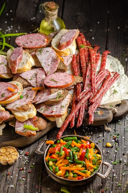 a lot of sandwiches with different types of sausages, delicacies, smoked grilled meat, black