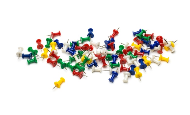 A lot of scattered paper push pins on an isolated white background