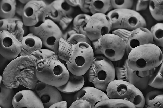 頭蓋骨の背景がたくさん、死者の休日の食べ物のハロウィーンの日のための抽象的なテクスチャキノコシャンピニーナ自然な装飾