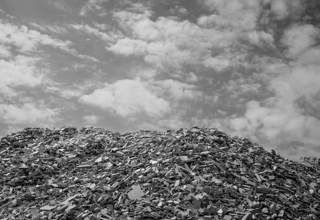 Lot of stone remains from a quarry with sky and clouds in the background black and white