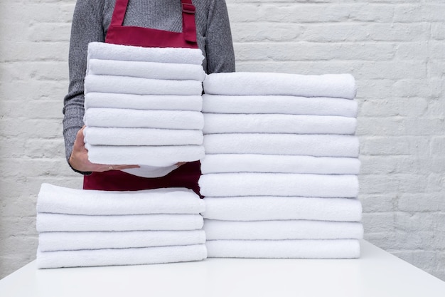 A lot towel white cleaning laundry hotel housemaid stack clean hand woman