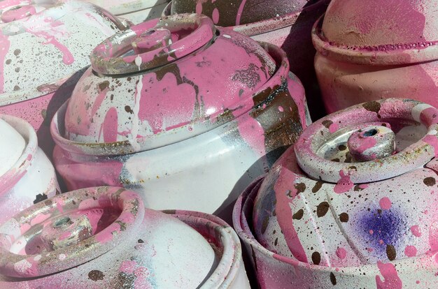 A lot of used pink metal tanks with paint for drawing graffiti