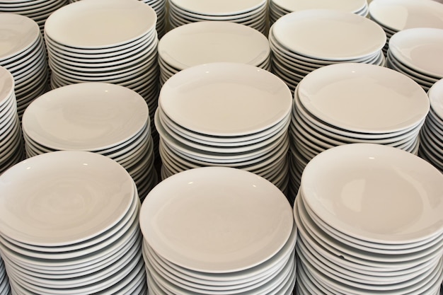 A lot of white plates in the dining room. stacks of clean dishes in a restaurant