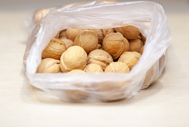 A lot of whole walnuts in a bag on a white background. Healthy, organic food with a high content of protein and protein.