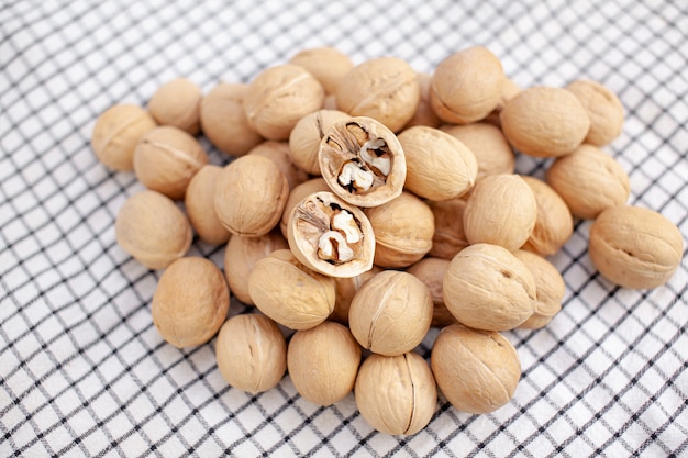 A lot of whole walnuts on a napkin close-up. Healthy, organic and healthy food with a high content of protein and protein.