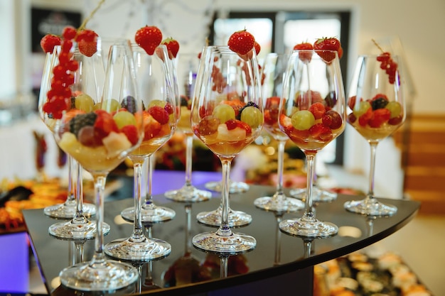 A lot of wine glasses with fresh fruit on the table at the ceremony Selective focus