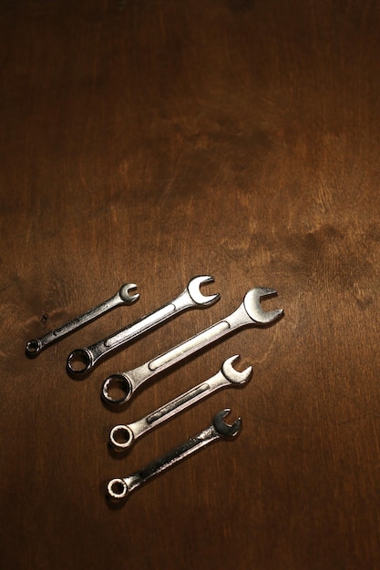 A lot of wrenches on a wooden background