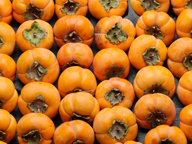 Lots of bright ripe persimmons in the box.