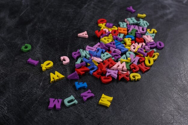 Lots of colored letters on a chalk board background. Back to school. Top view.