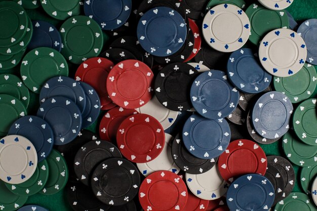 Photo lots of colorful casino poker chips lie on a green velvet gaming table. background for gambling.
