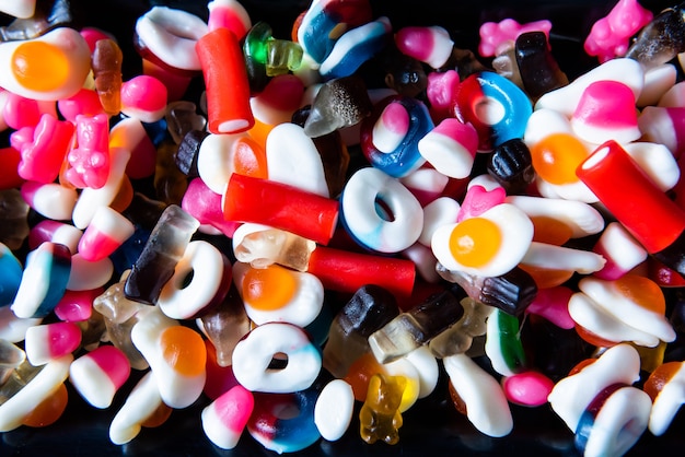 Foto un sacco di caramelle colorate, caramelle gommose, dolci e caramelle per un compleanno. festa di caramelle miste sfondo.