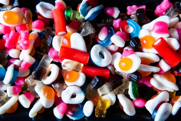 Lots of colorful sweets, gummies, sweets and candies at a birthday. party mixed candy background.