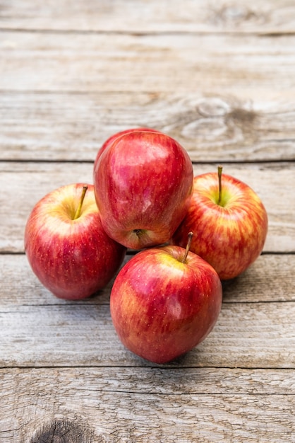 Lots of delicious and juicy apples on a wooden background.