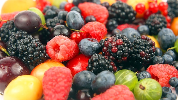 Lots of fresh different berries on a white background. Useful vitamin berry fruit food