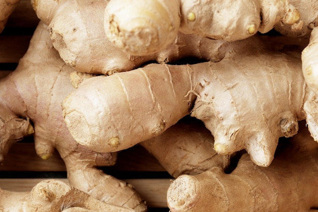 Lots of fresh ginger on a textured background.