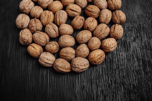 Lots of fresh nuts on a black wooden background. Best practices for designer. A beautiful design from the nuts