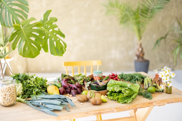 Lots of fresh vegetables fruits and greens on table indoors