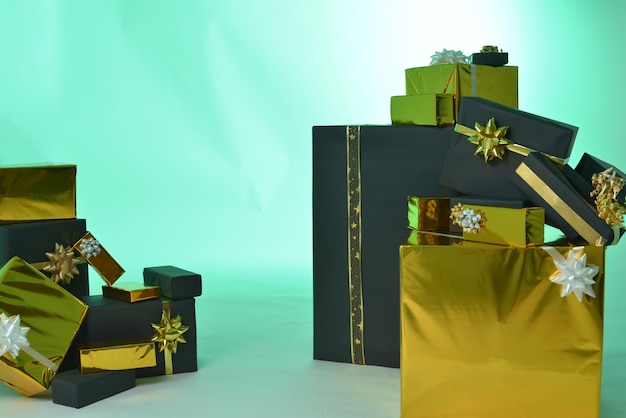 Foto un sacco di scatole regalo di colore nero e oro su uno sfondo verde