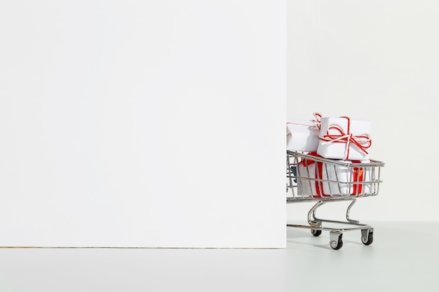 Lots of gifts in the shopping cart on a white.