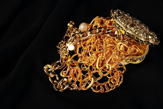 Lots of golden jewelry over a black background