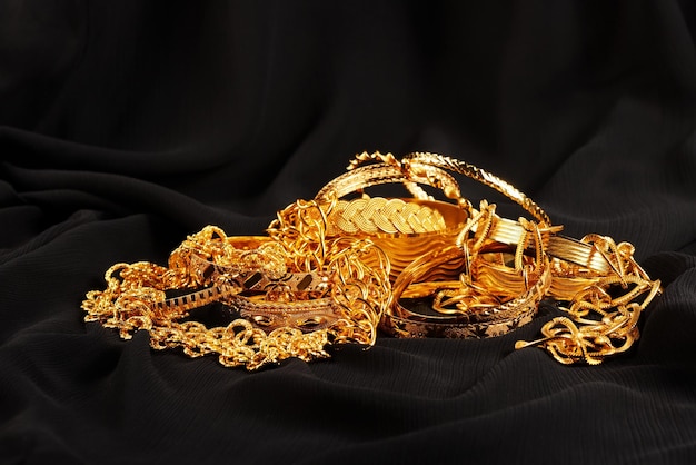 Photo lots of golden luxury jewels over a black background