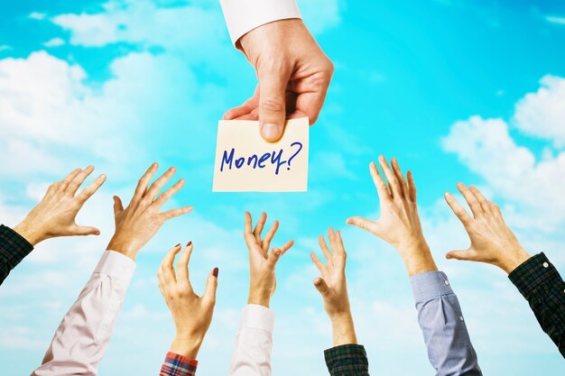 Lots of hands amid sky with clouds people are drawn to the opportunity to get money concept on the topic of earnings
