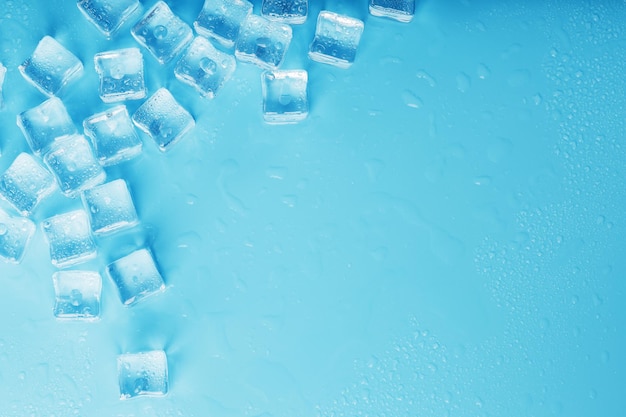 Lots of ice cubes with water drops scattered on a blue background