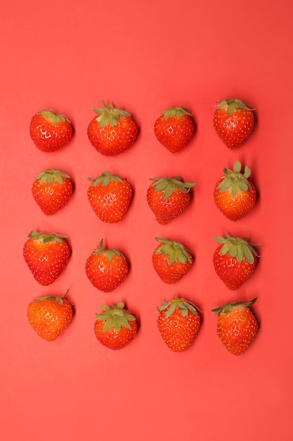 Lots of juicy red strawberries on a red background in full screen