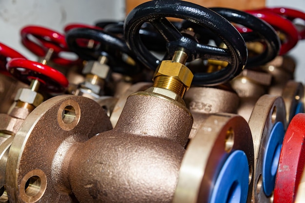 Lots of new valves stacked on a shelf in a workshop closeup