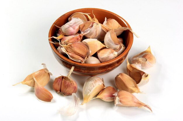 Lots of organically grown garlic cloves on a white background