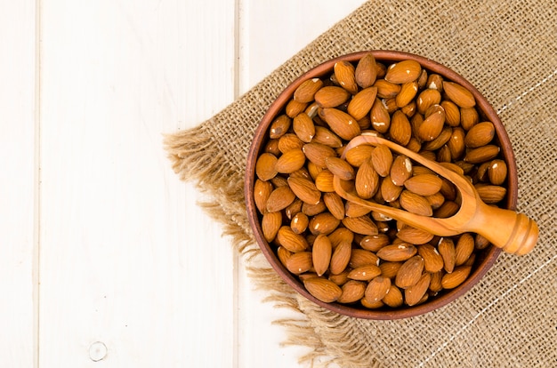 Lots peeled almonds in wooden bowl. Photo