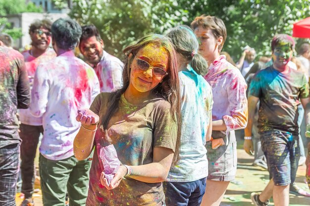 Photo the lots of people in the color fest colored faces of the peoples color festival in india