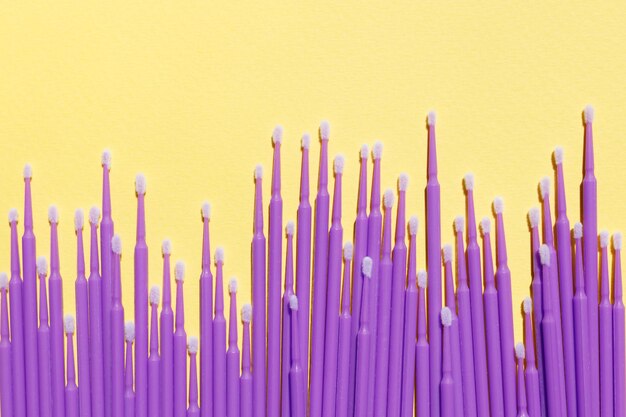 Photo lots of purple microbrushes on a yellow background