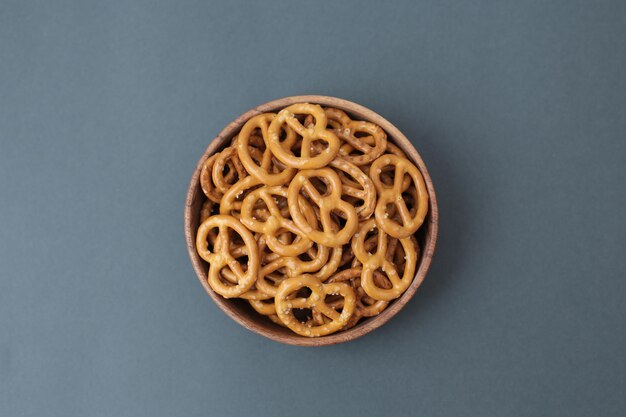 Lots of salted pretzels on a gray background full screen