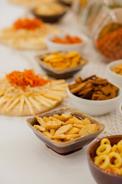 A lots of salty snacks on a table, many cheese and crackers on the table with snacks