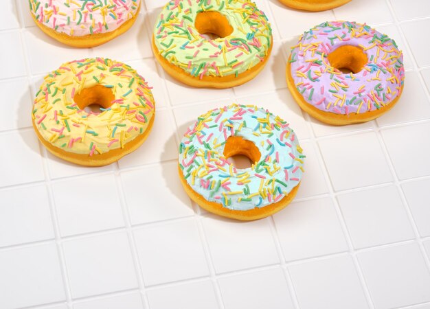 Lots of unreal tasty fresh donuts with sprinkles on the holiday table Dessert on a birthday party