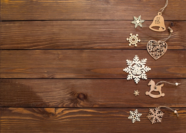 Lots of wooden toys for Christmas tree on wooden background top view.