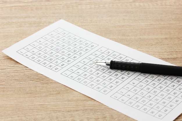 lottery ticket and pen on wooden background