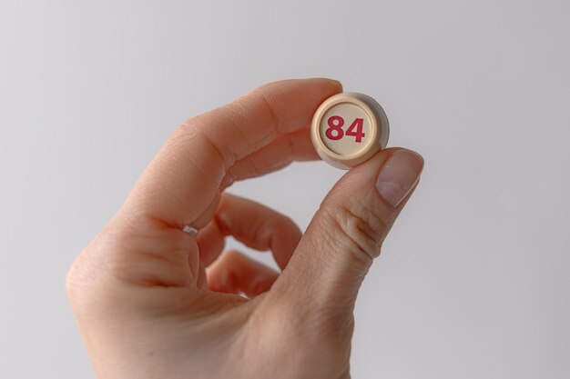 Photo lotto barrel with the number 84 in a womans hand female hand lotto keg a twodigit number