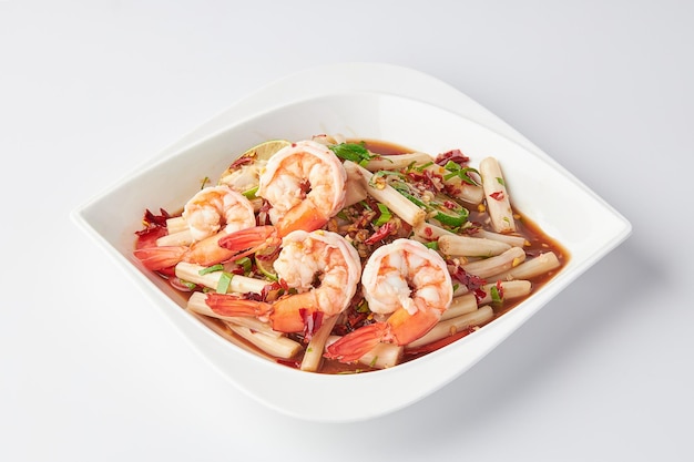 Lotus roots spicy salad with prawns served on a white plate isolated on white background