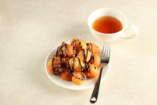 Loukoumades, luqaimat of lokma met chocolade topping met kleurrijke hagelslag in een wit bord