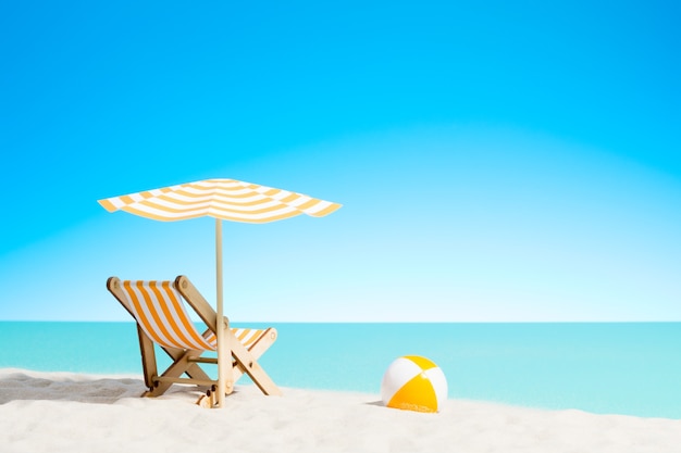 Lounge chair with parasol and beach ball on the coast, sky with copy space