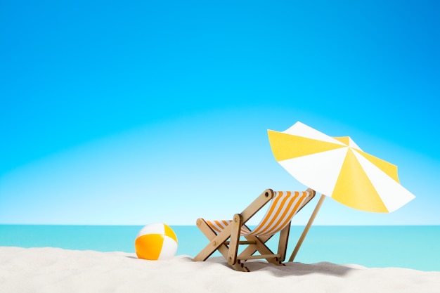 Photo lounge chair with parasol and beach ball on the coast